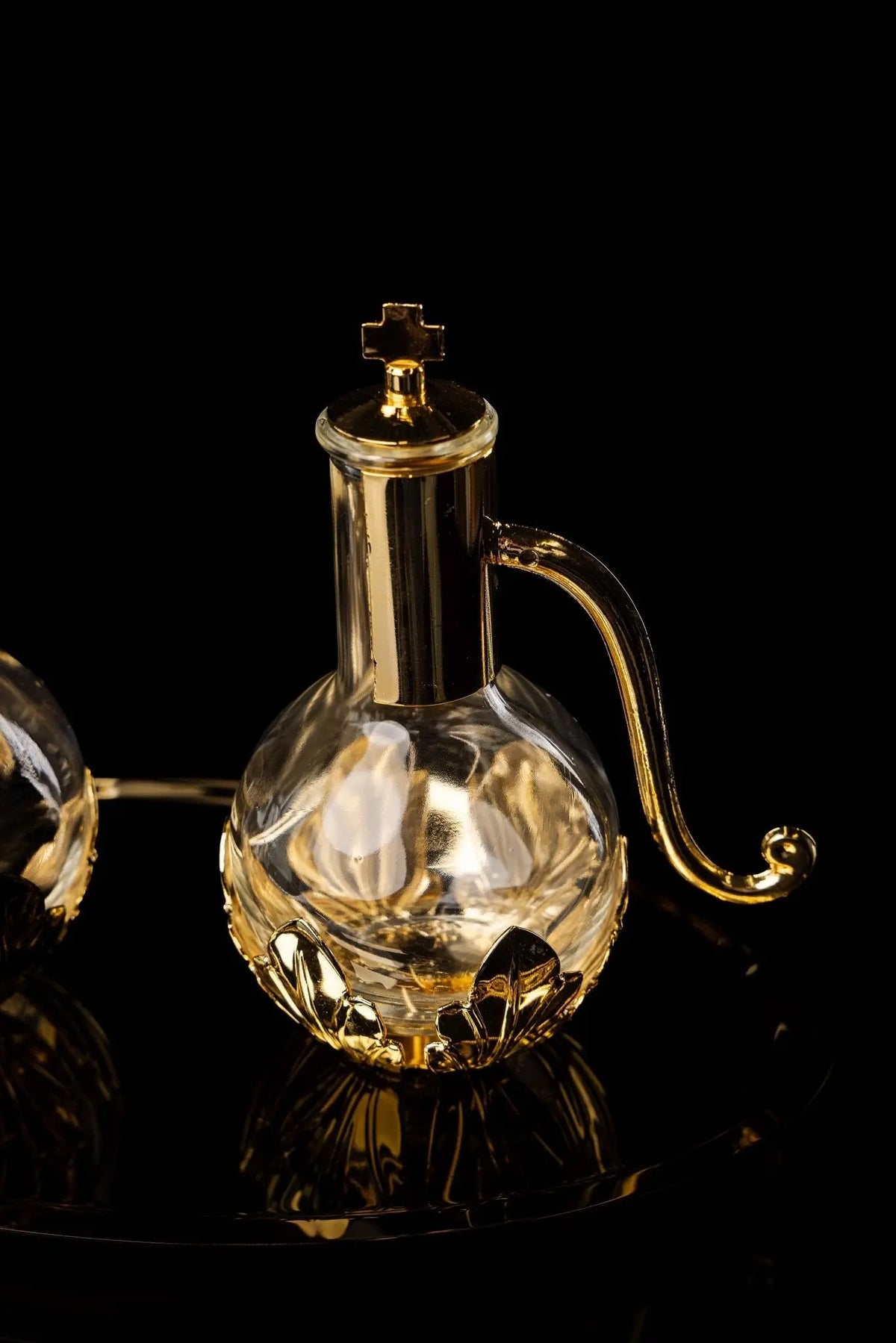 Gold liturgical cruet with floral accents and cross lid, side view