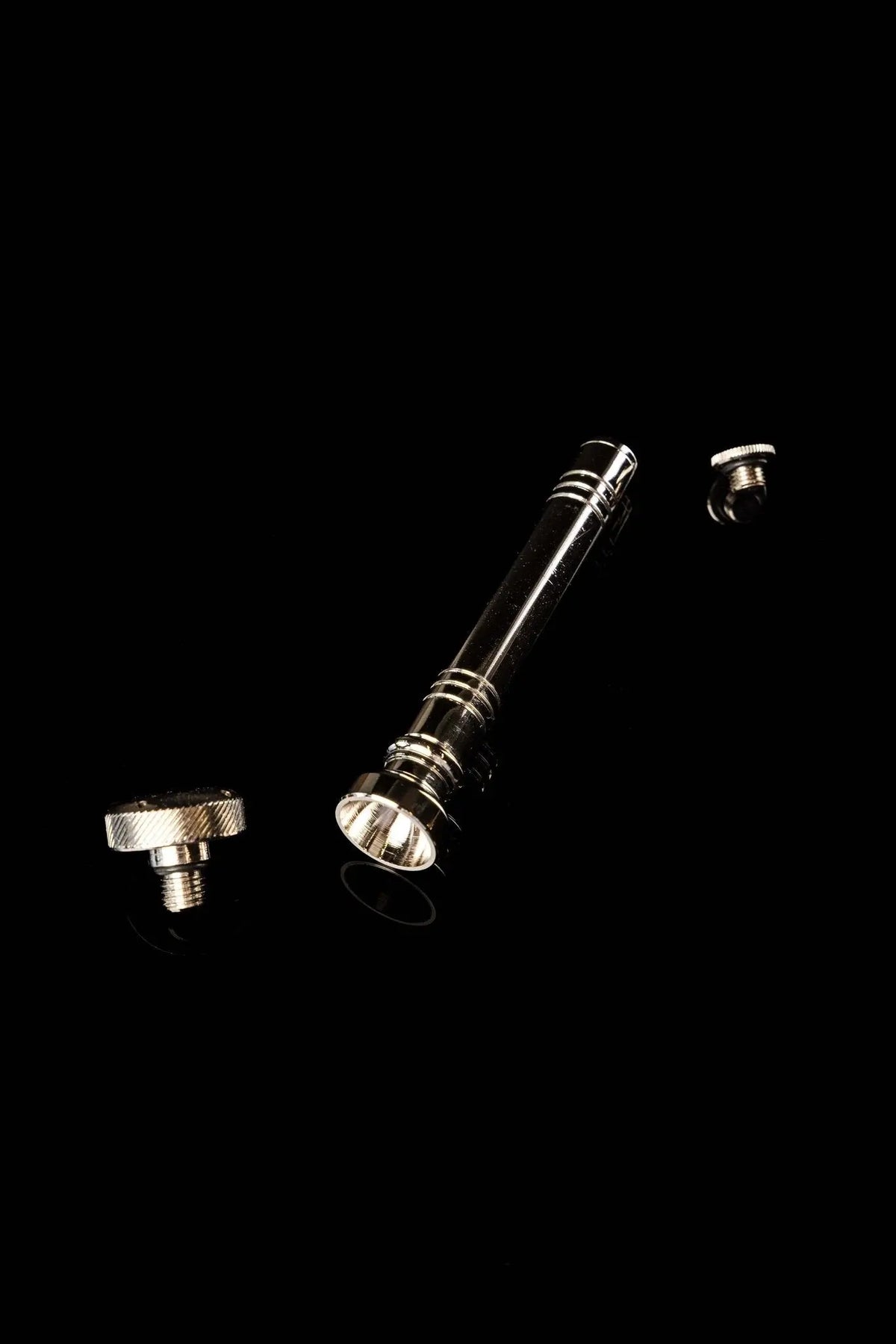 Silver aspergillum with threaded opening and detached end caps, disassembled view