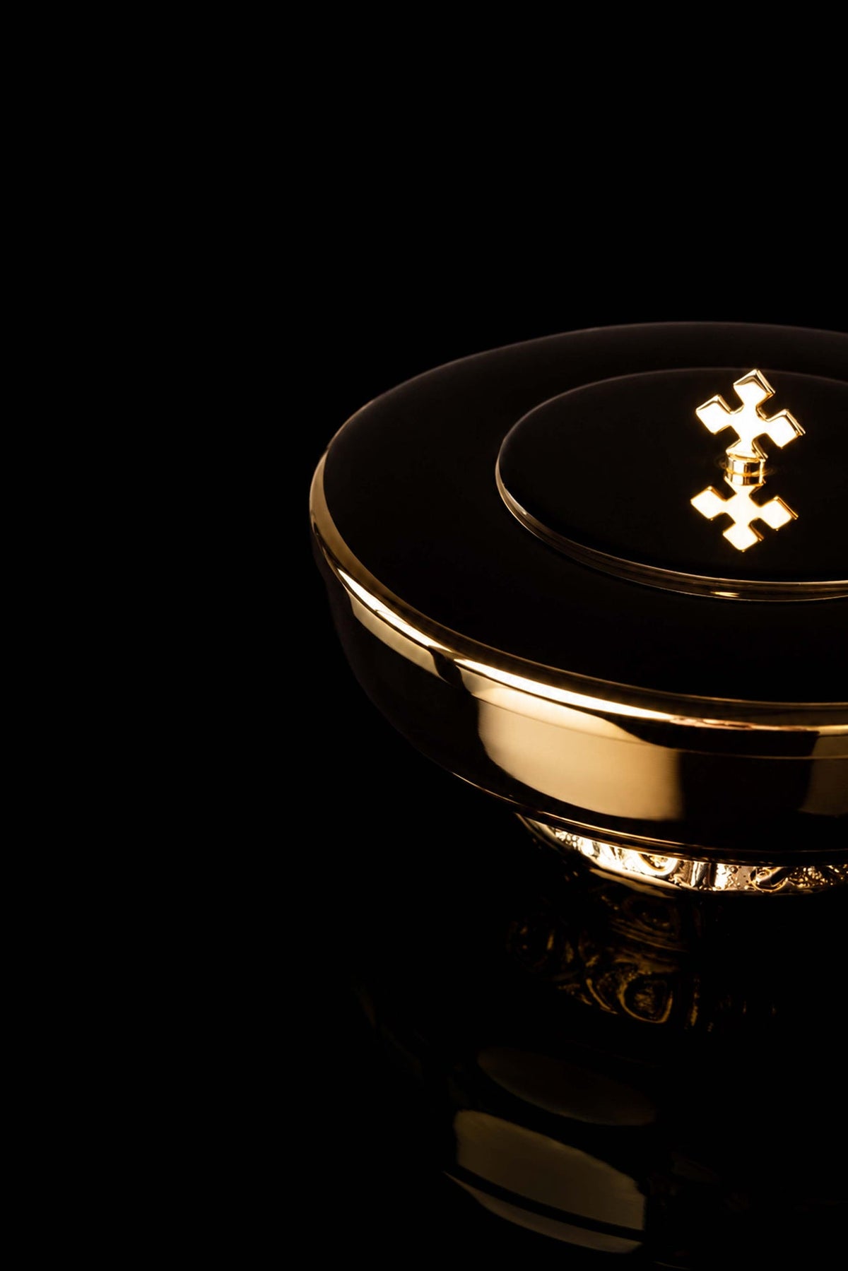 Gold-plated ciborium with decorative cross, angled view of lid and base