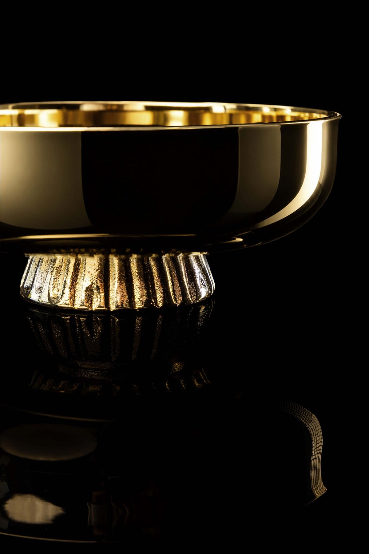 Gold paten with fluted pedestal, close-up side view
