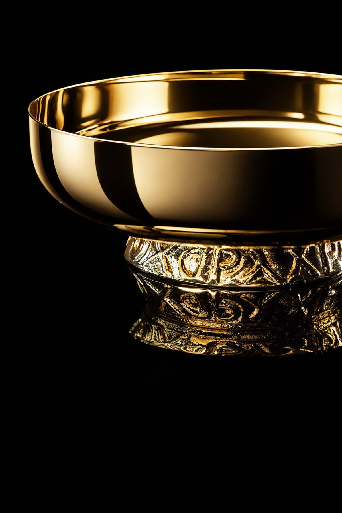 Gold-plated paten with ornate nodus, close-up side view