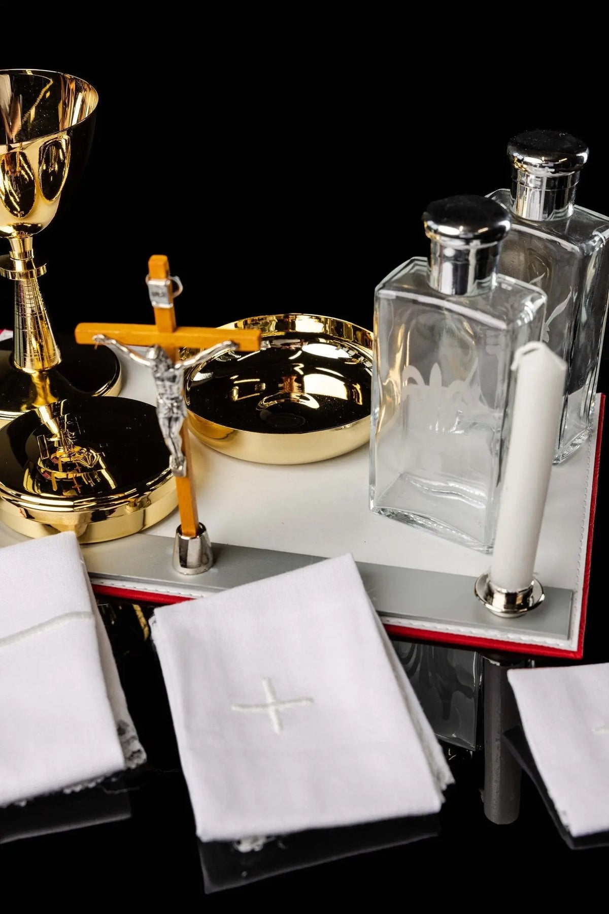 Rosso equipaggiamento liturgico con calice, patena, croce e candele, vista ravvicinata