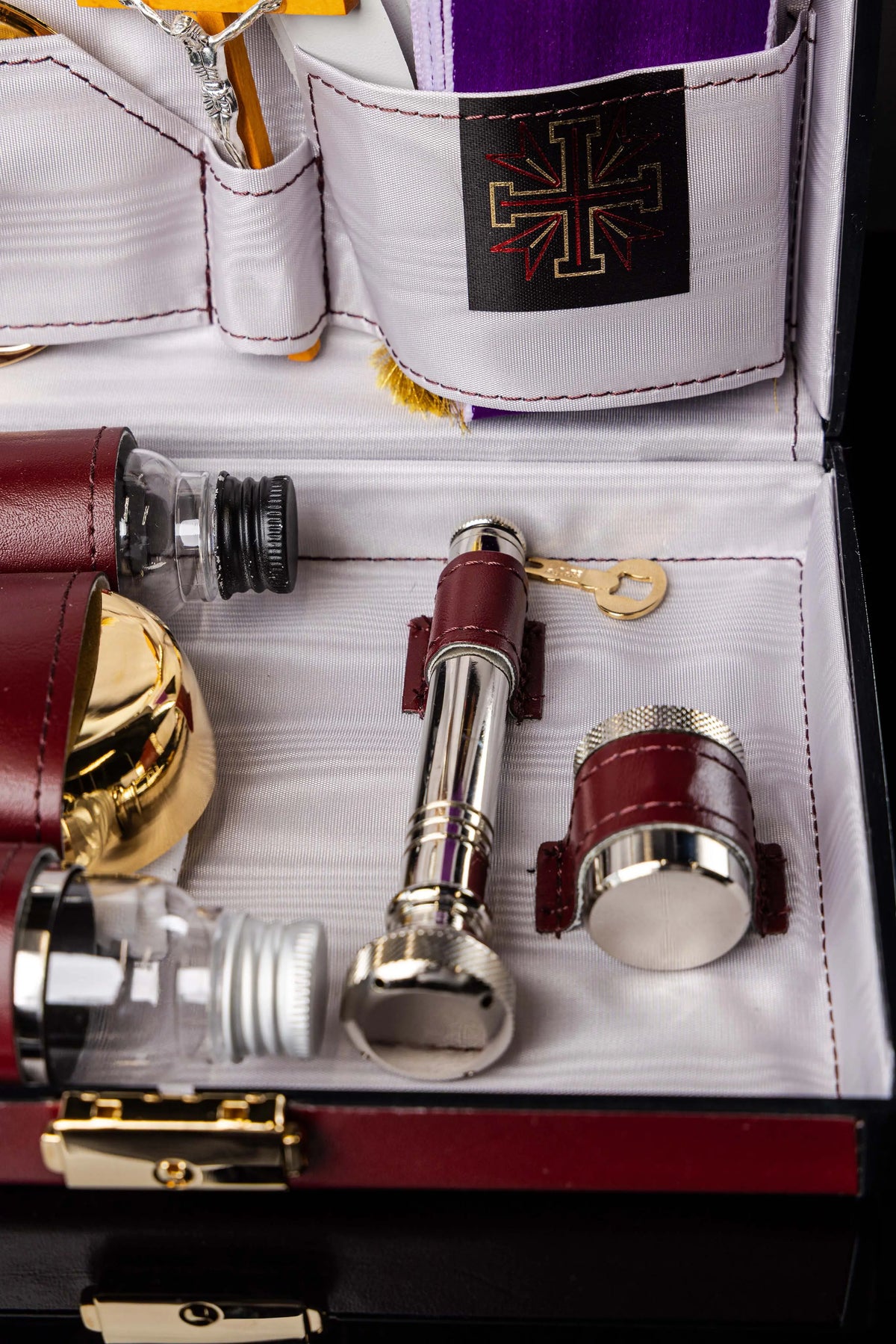 Valigetta liturgica bordeaux con aspersorio, apribottiglie e accessori, dettaglio interno