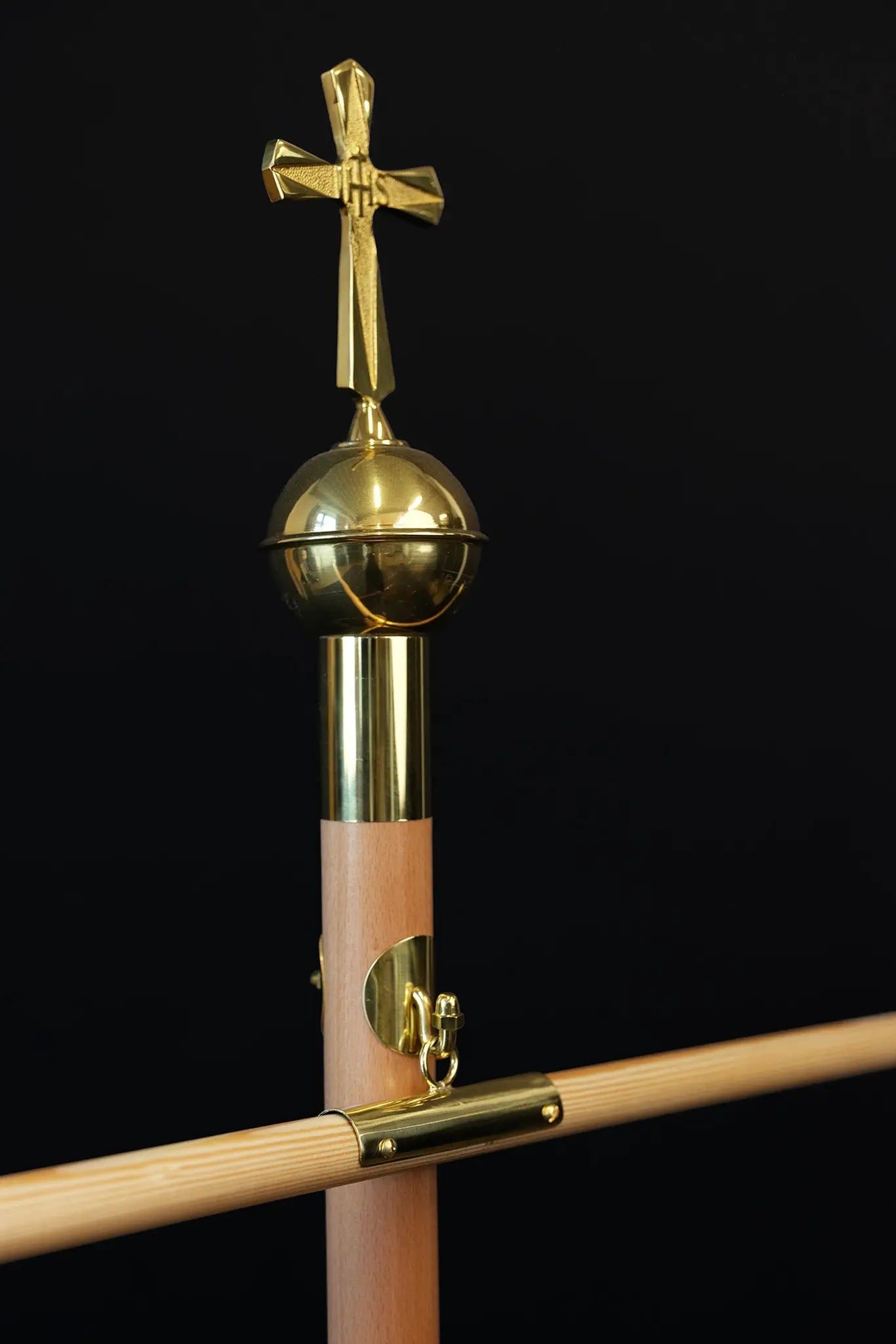Light wood processional banner pole with decorative cross and gold metal accents