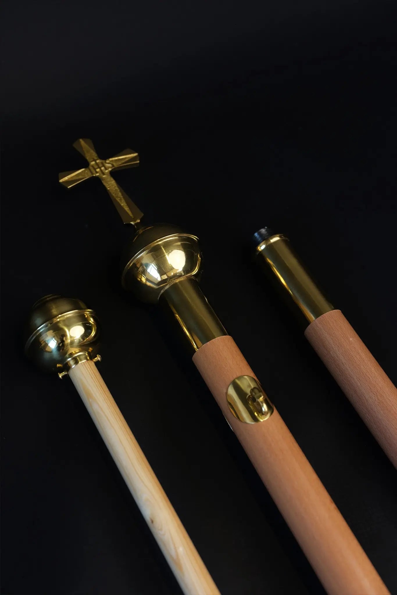 Light wood processional banner pole with decorative cross and gold metal accents