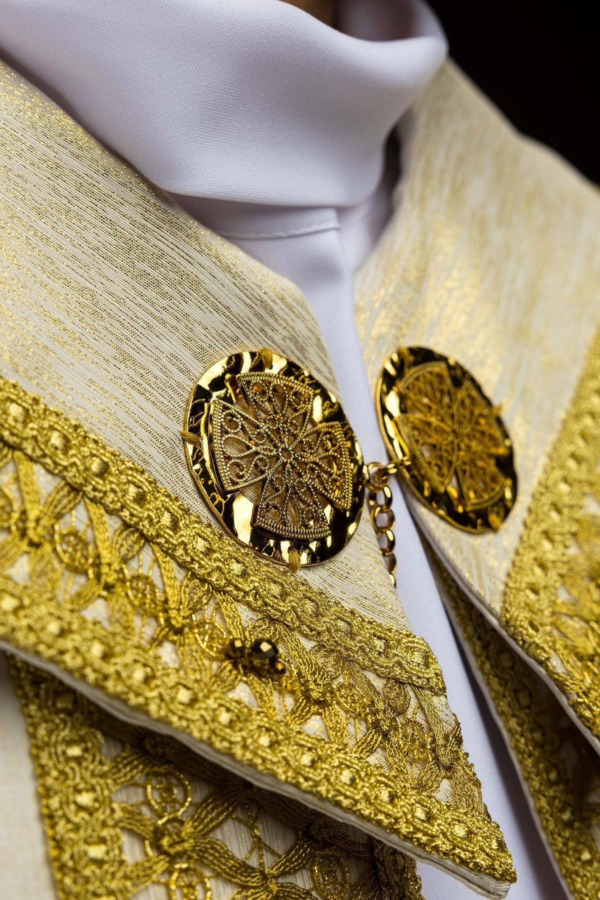 Marfim ecru capa de asperges com bordado dourado, close-up do fechamento