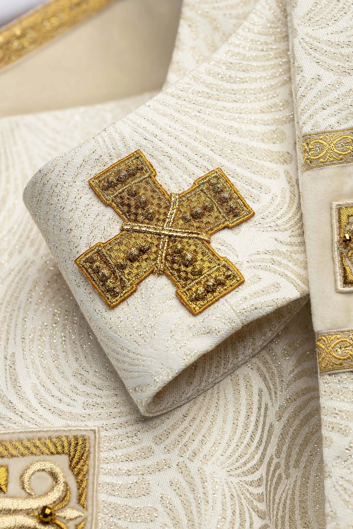 Ecru Easter chasuble with embroidered cross and gold appliqué, close-up