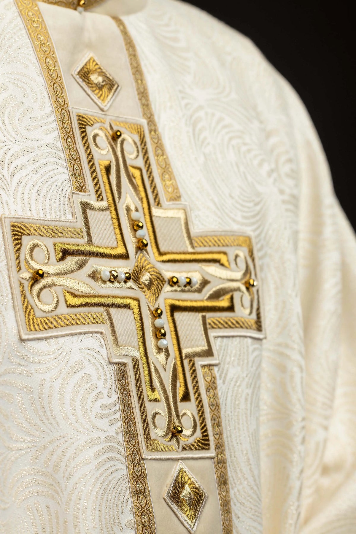 Ecru Easter chasuble with embroidered cross, angled close-up