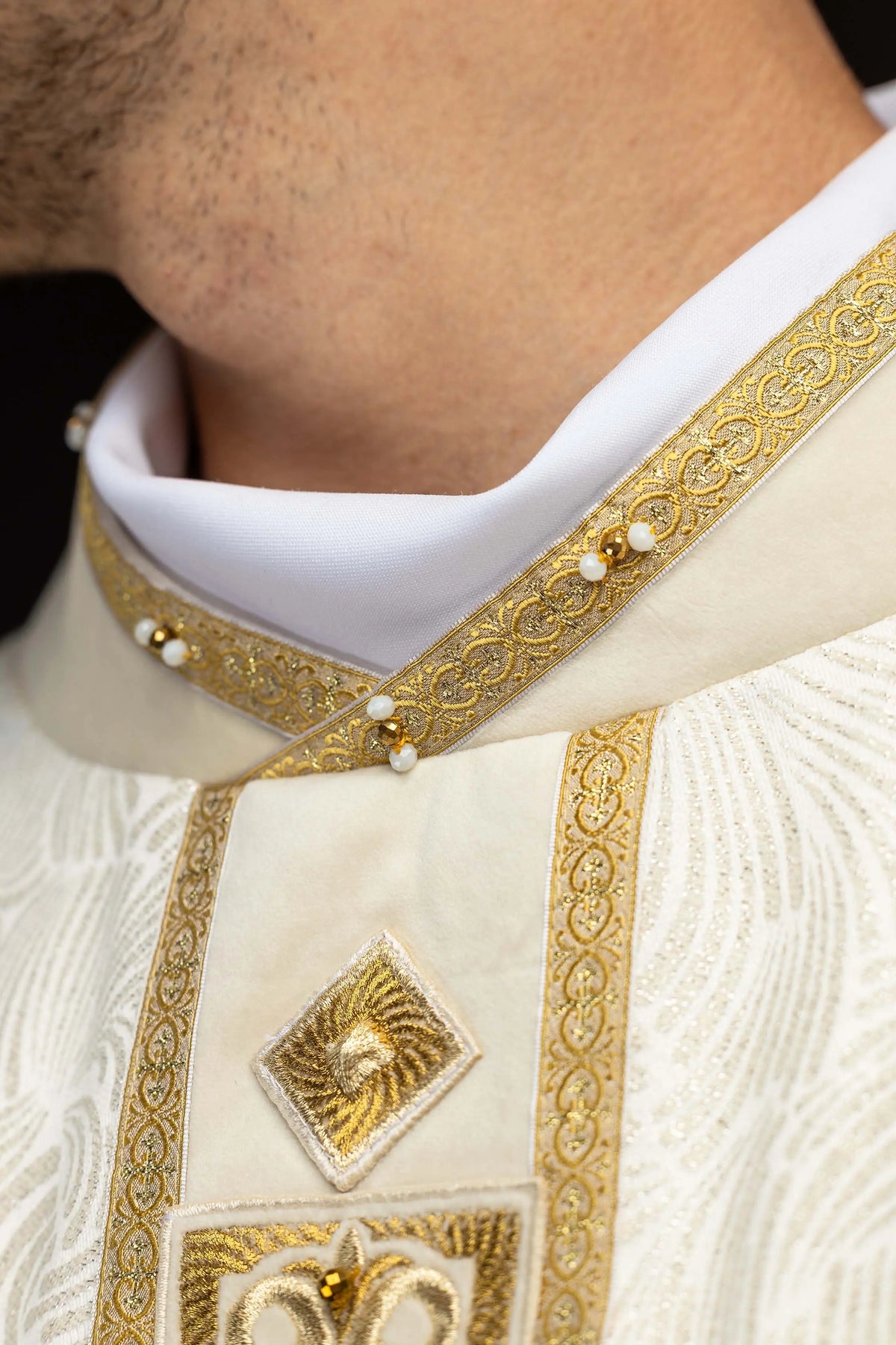 Ecru Easter chasuble with embroidered cross and gold trim, collar close-up