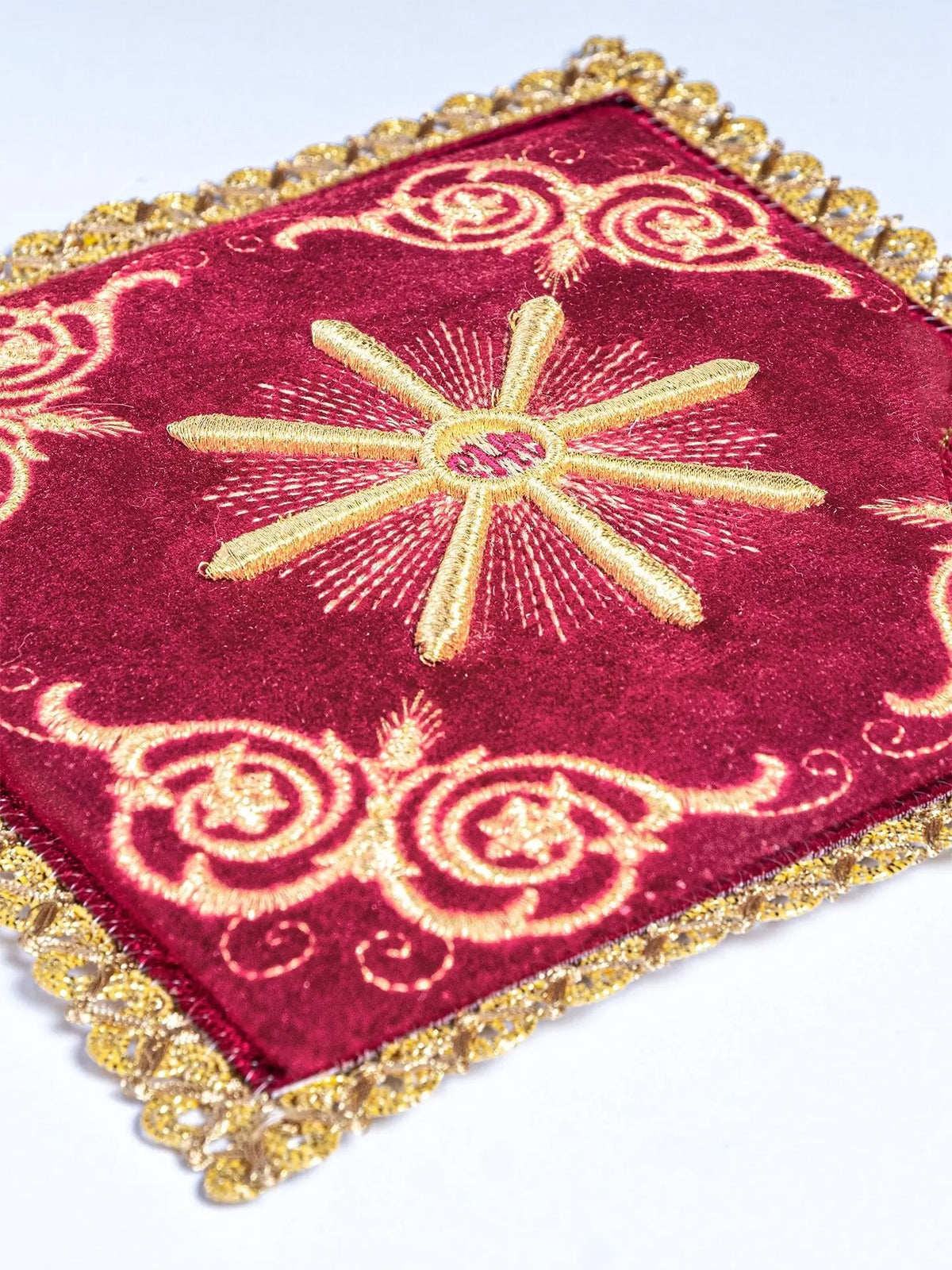 Red velvet altar linen with embroidered Eucharistic motif, close-up view