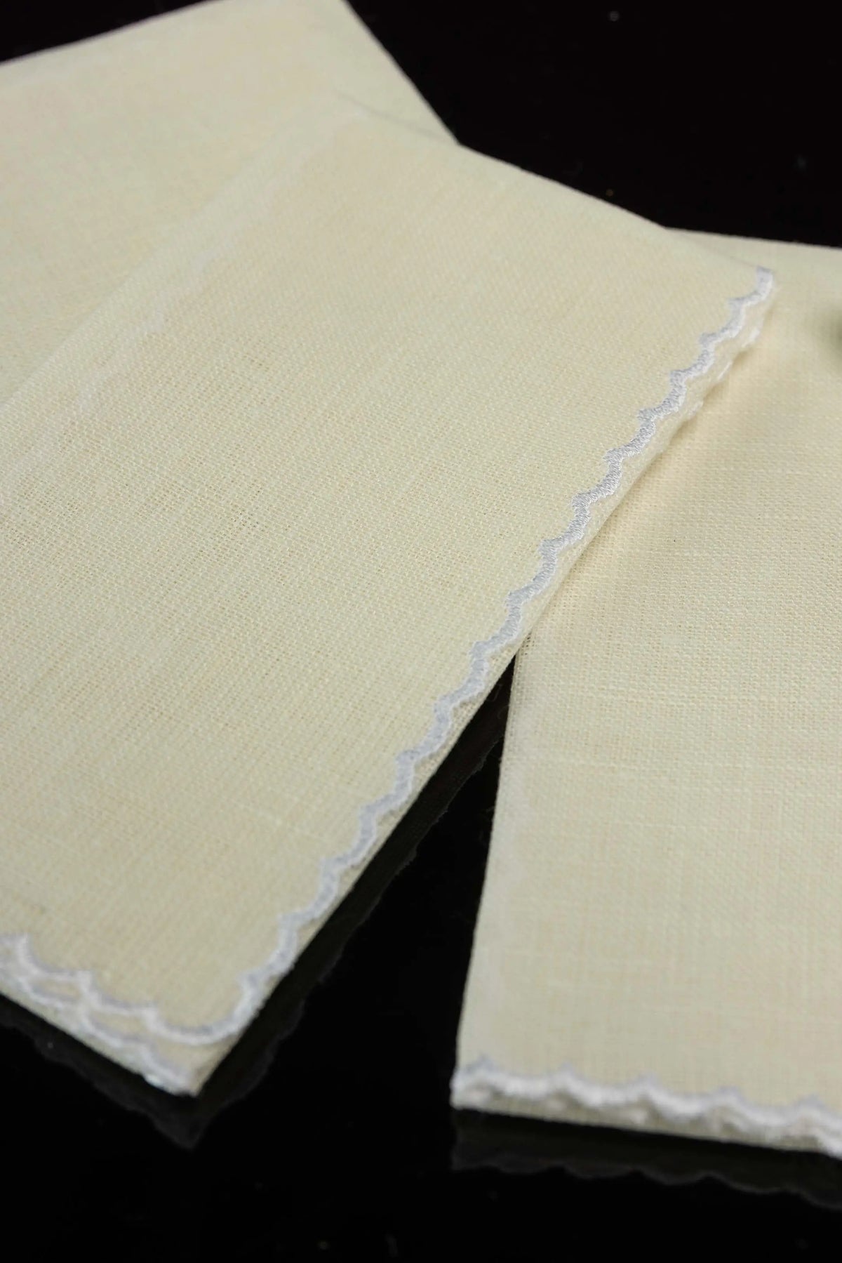 Ecru linen lavabo towels with scalloped edges, detail view