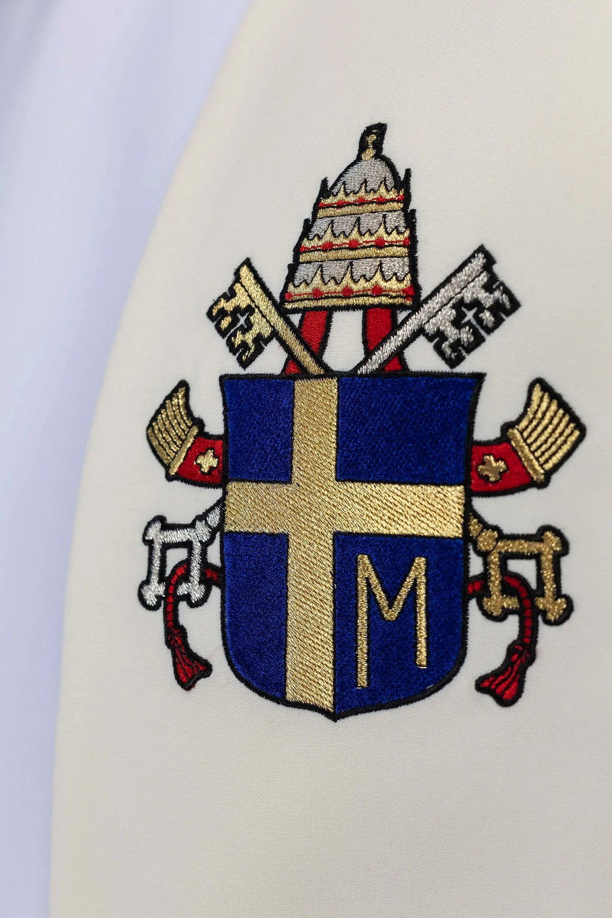 Ecru stole with papal coat of arms embroidery, close-up view