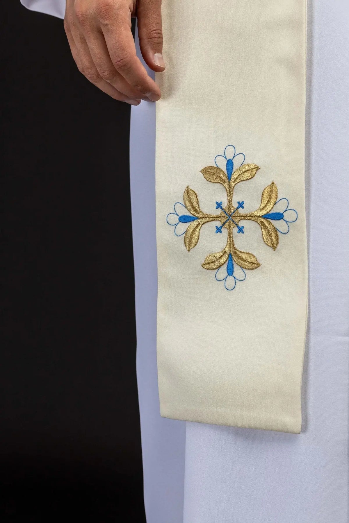 Ecru stole with a blue and gold floral cross, close-up view
