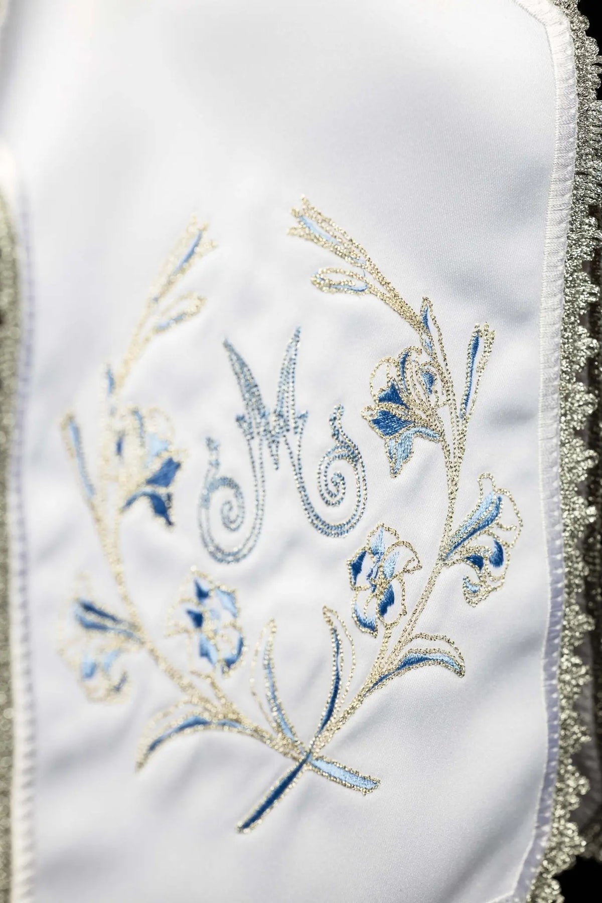 White ciborium veil with silver Marian embroidery, close-up of embroidered Marian monogram