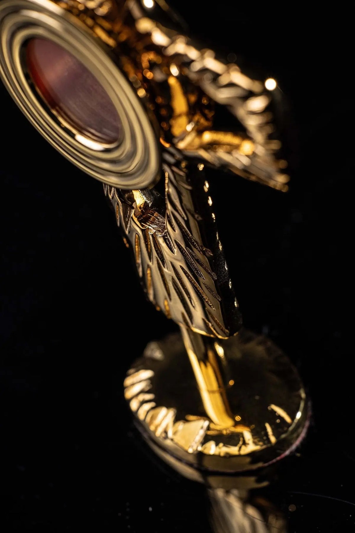 Gilded brass cross-shaped reliquary, side close-up showing its depth and stand