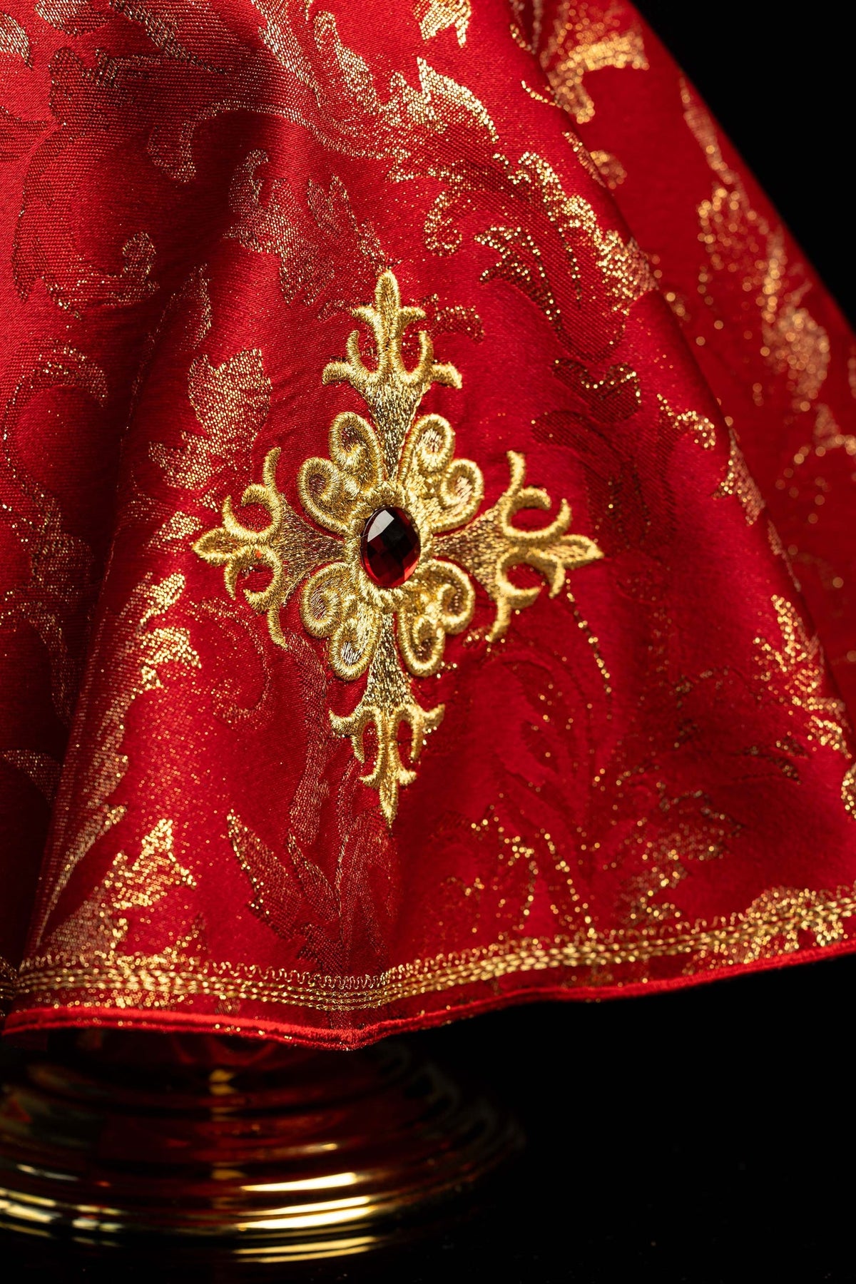 Red ciborium veil with embroidered gold cross, close-up view