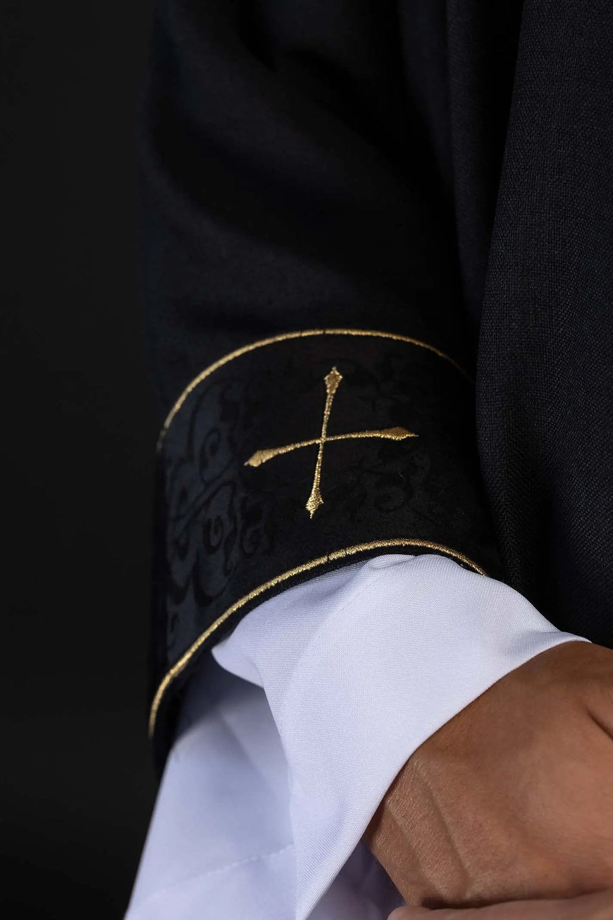 Black chasuble with gold cross, sleeve cuff close-up