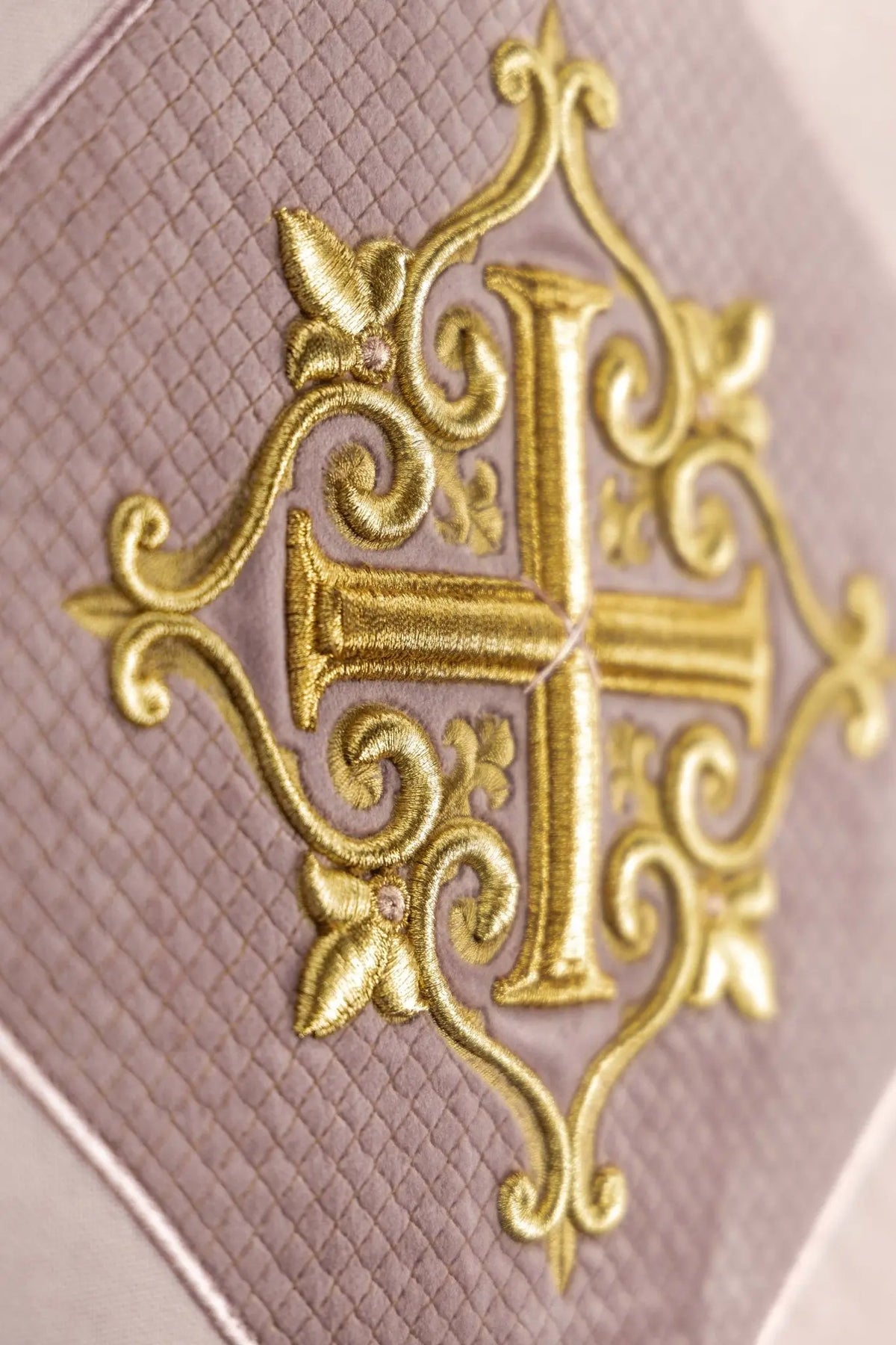 Rosa toalha de ambão com cruz dourada bordada, close-up lateral do bordado