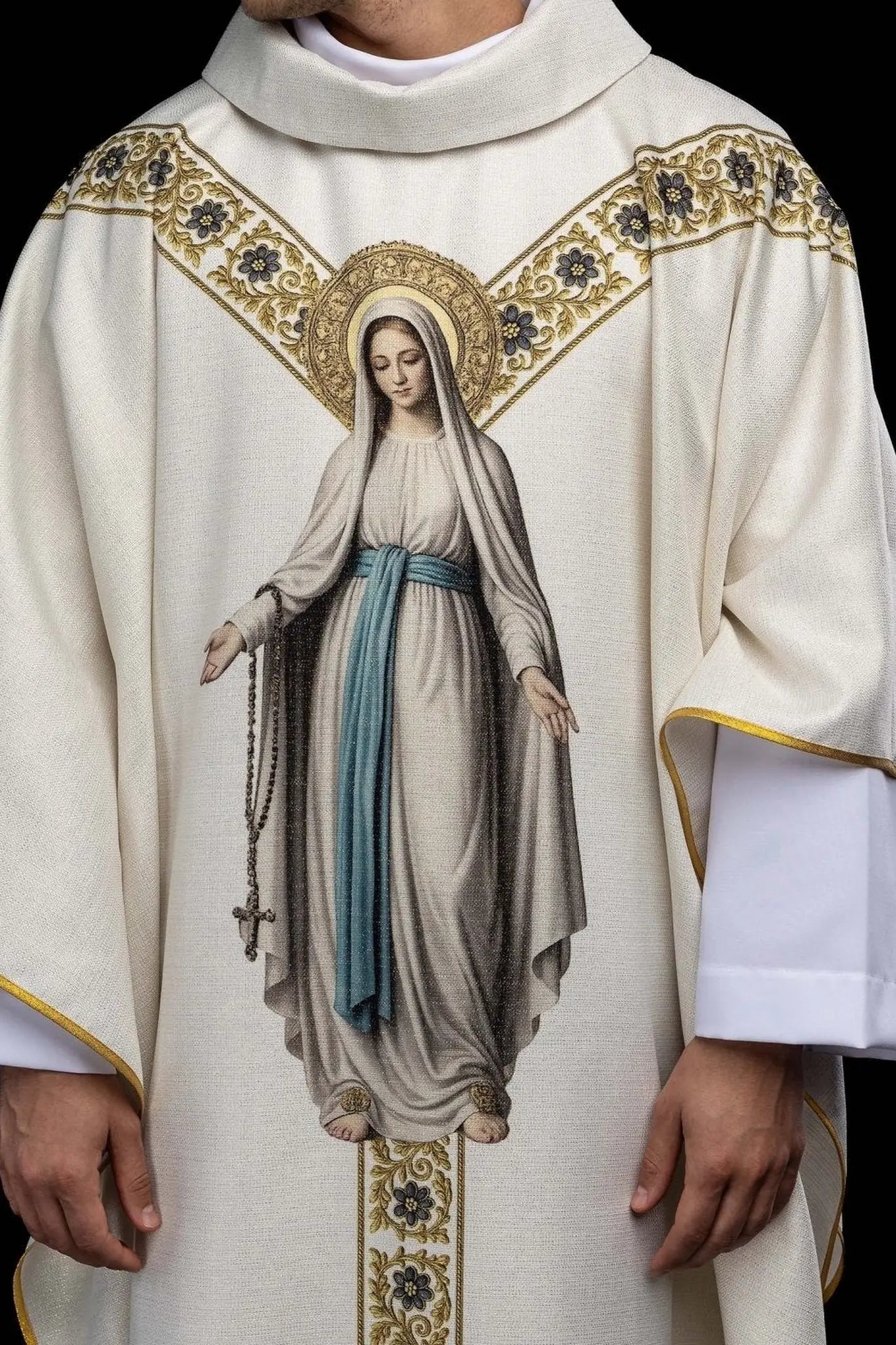 Ecru chasuble with printed image of Our Lady of Lourdes, featuring a blue sash and gold floral motifs, with a matching stole.